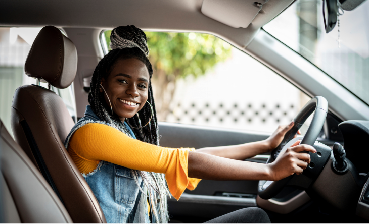 photo of a driver smiling inside a electric vehicle